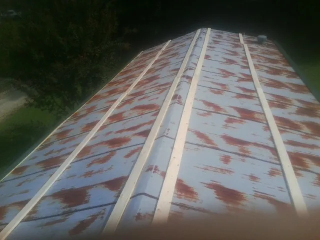Rusted metal roof panels with new wood purlins before replacement — Storm Damage Roof Repair in Wadesville by Roofing Brothers