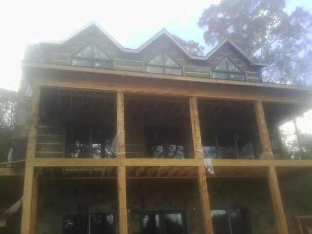 Dormers and porch framing on a large log home under construction — Roof Coating work by our crew in Wadesville