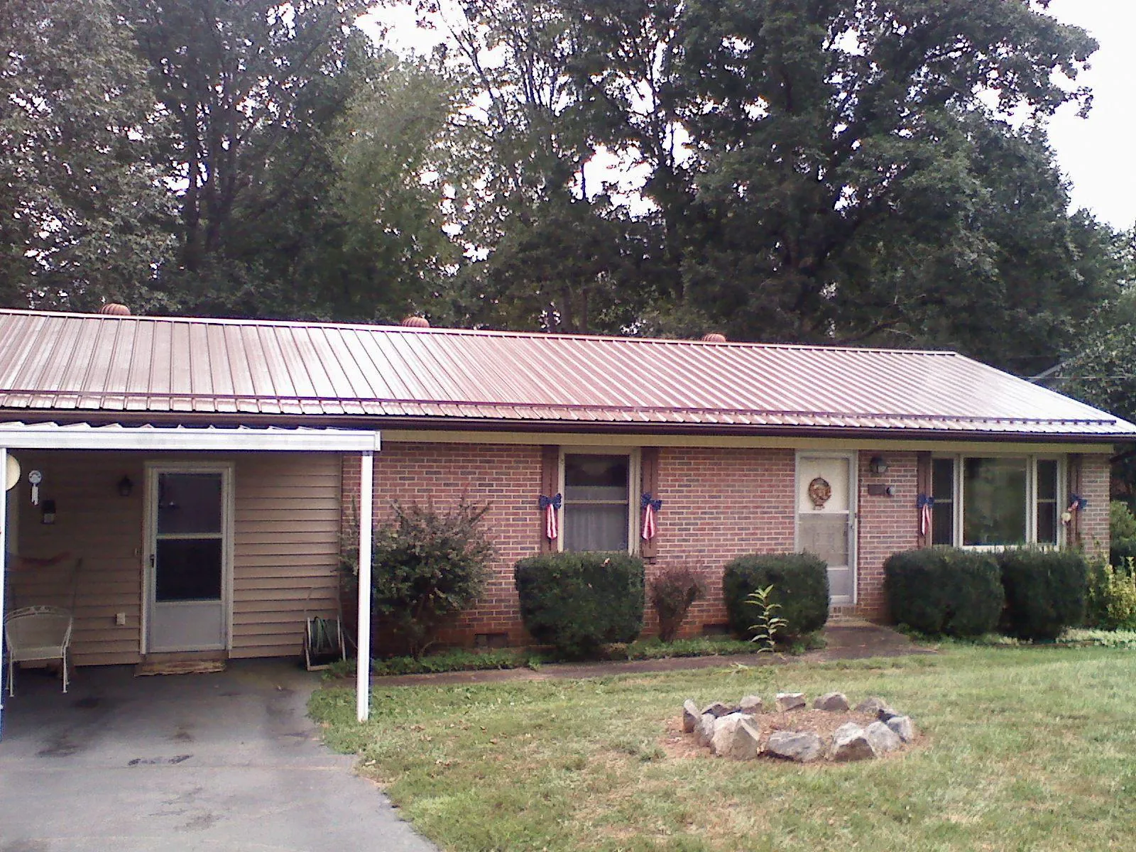 Bronze metal roof and carport on a brick ranch home — Roof Repair work by our crew in Wadesville